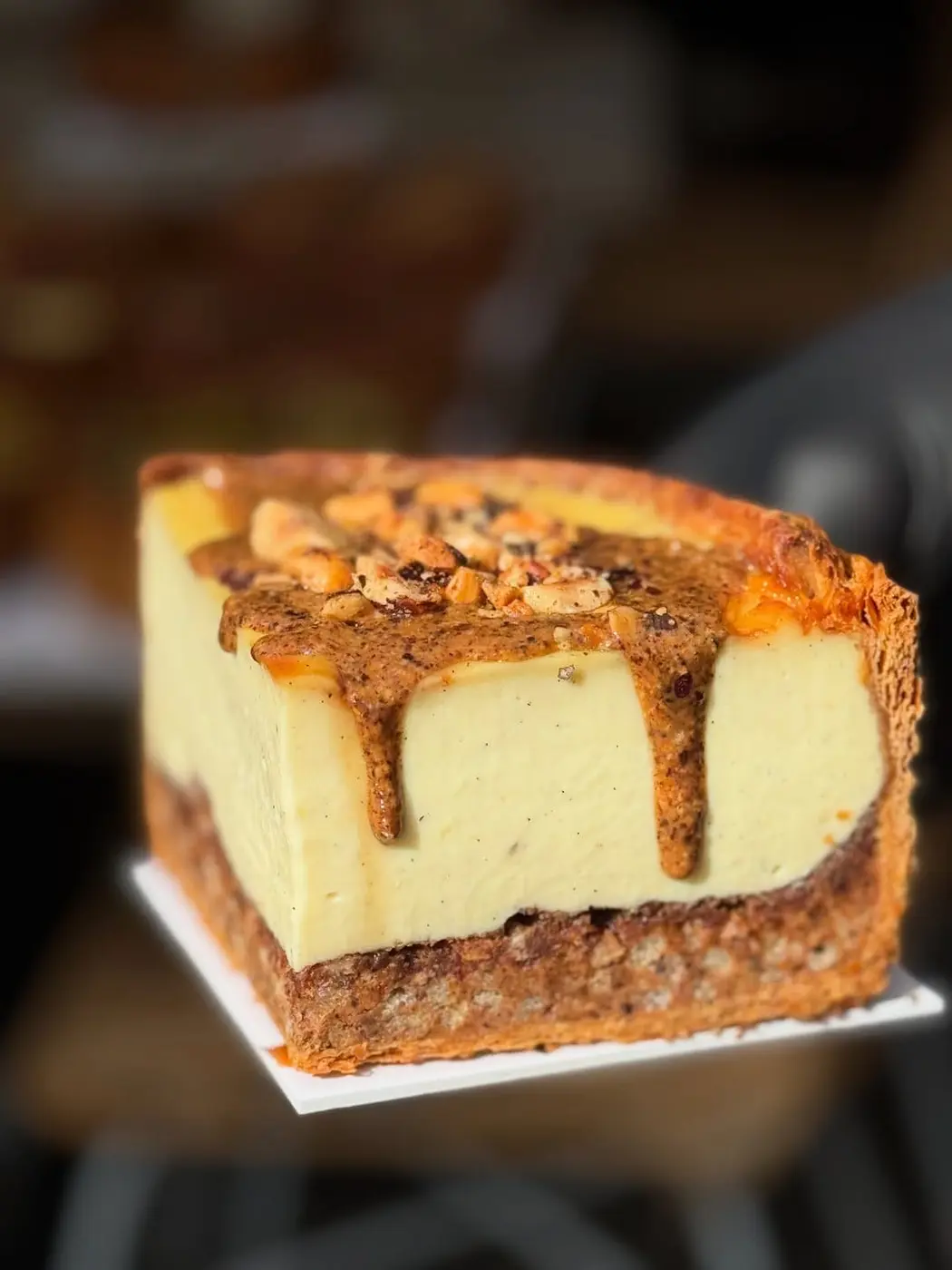 Notre cheesecake à la vanille, croûte de noix concassées et coulis de dattes caramélisées — la pâtisserie que nos clients recommandent le plus.
